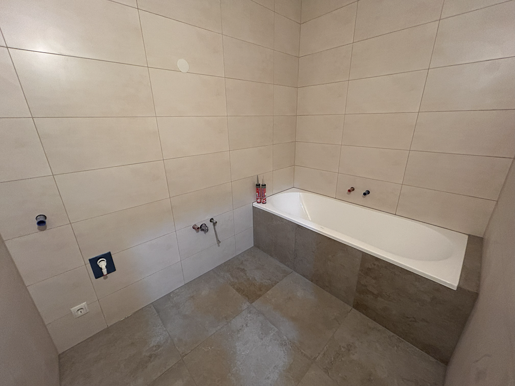 „Video zeigt die Anwendung des REVIMAG-Systems an einer Badewanne: Die magnetisch befestigte Fliese wird geöffnet, die REVIMAG-Schraube ein- und ausgedreht und die Fliese wieder unsichtbar geschlossen.“